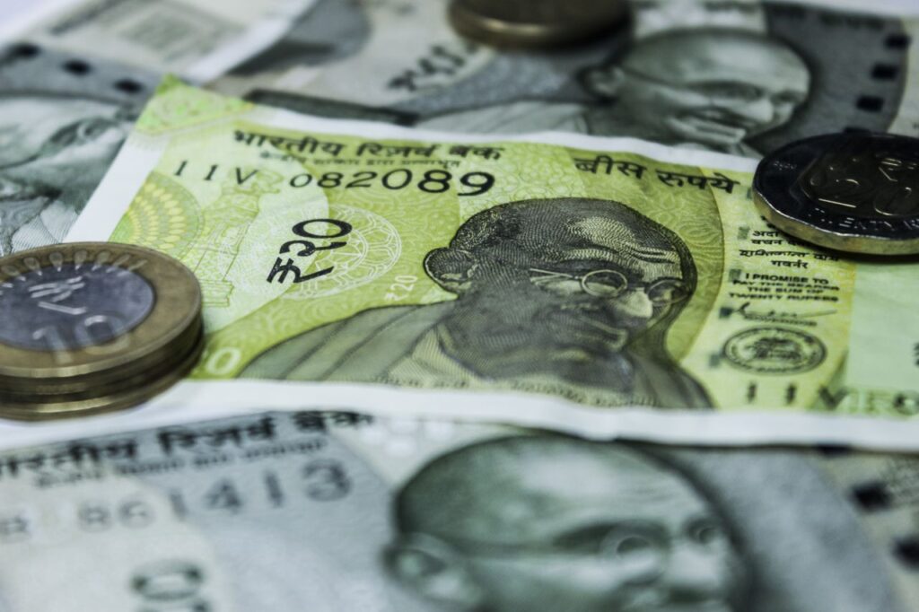 Close-up shot of Indian currency notes and coins, highlighting economic themes.